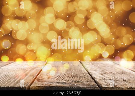 Superficie di legno vuota e luci di Natale sfocate sullo sfondo, effetto bokeh Foto Stock