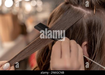 Parrucchiere coiffeur rende i capelli Closeup Foto Stock