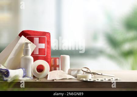 Kit casa di emergenza su tavolo di legno e sfondo caldo della stanza. Composizione orizzontale. Vista frontale. Foto Stock