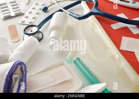 Assortimento di attrezzature mediche portatili di pronto soccorso di base su tavolo bianco. Composizione orizzontale. Vista rialzata. Foto Stock