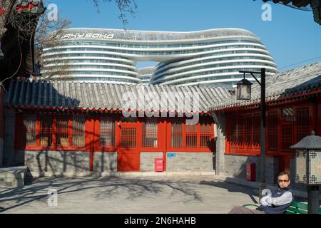 Un turista si riposa al Tempio di Zhihua a Pechino, con edifici moderni in lontananza. 31 gennaio 2023 Foto Stock