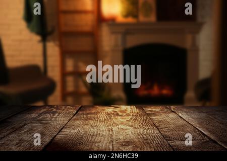 Superficie in legno vuota e vista sfocata del camino in camera Foto Stock