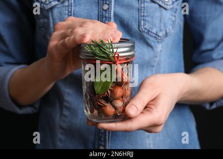 Donna che tiene vaso con potpourri aromatici, primo piano Foto Stock
