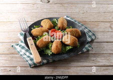Crocchette fritte tradizionali spagnole su tavolo di legno Foto Stock