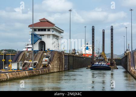 Un rimorchiatore sposta una draga dalla divisione dragaggio del canale di Panama nella camera di chiusura delle chiuse di Miraflores. Canale di Panama. Foto Stock