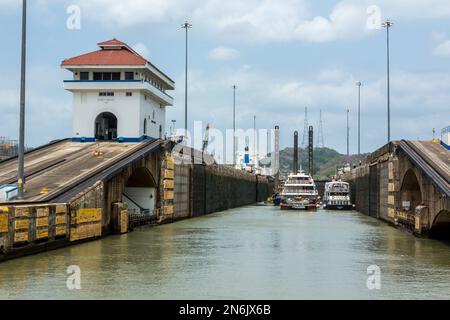 Le barche del tour e un drago condividono lo spazio nella camera della serratura presso le chiuse di Pedro Miguel. Canale di Panama, Panama. Foto Stock