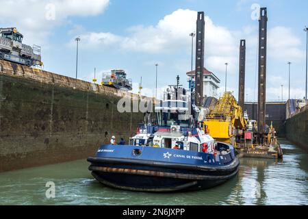 Un rimorchiatore sposta una draga dalla divisione dragaggio del canale di Panama nella camera di chiusura delle chiuse di Miraflores. Canale di Panama. Foto Stock