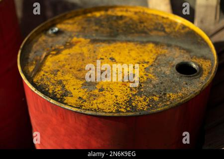 Barile carburante con coperchio giallo. Serbatoio carburante rosso. Vecchio canister. Serbatoio dell'acqua. Foto Stock