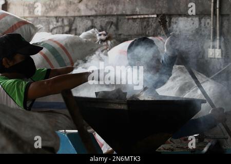 10 febbraio 2023, Bantul, Regione Speciale di Yogyakarta, Indonesia: I lavoratori fabbricano mattoni a partire da rifiuti di plastica in un sito di gestione dei rifiuti a Bantul, Regione Speciale di Yogyakarta. Il sito di gestione dei rifiuti gestisce in modo indipendente i rifiuti organici in compost e i rifiuti inorganici in mattoni di plastica. (Credit Image: © Angga Budhiyanto/ZUMA Press Wire) SOLO PER USO EDITORIALE! Non per USO commerciale! Foto Stock