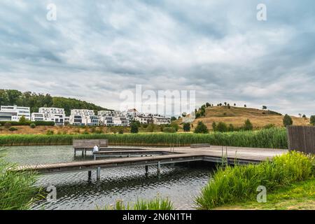 Vista sul lago Phoenix (Phoenixsee) a Dortmund, Germania, con ville moderne e la collina Kaiserberg, spazio copia Foto Stock