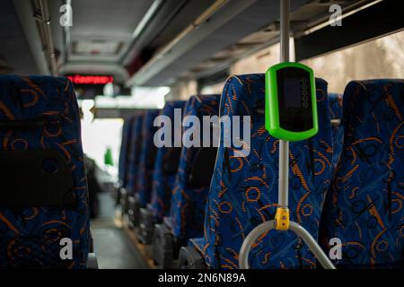 Interno dell'autobus. Sistema di lettura biglietti in bus. Sedili blu per i passeggeri. Foto Stock