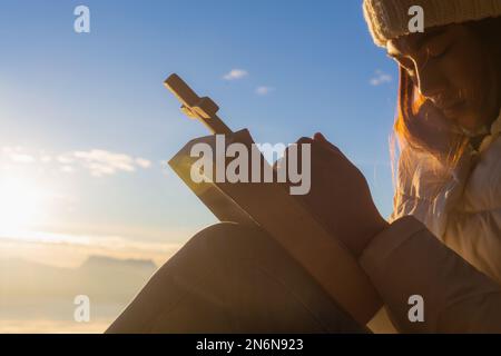 Le donne pregano Dio con la Bibbia e la croce sullo sfondo di montagna con l'alba del mattino. Donna prega per la benedizione di dio a desiderare avere un l migliore Foto Stock