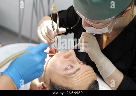 l'uomo adulto che prega con gli occhi guarda il medico che lacrima il suo dentista fa male alla richiesta dell'uomo donna Foto Stock