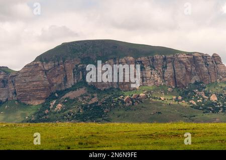 Strati di roccia o strati che mostrano chiaramente primo piano sul tipico paesaggio di Drakensberg montagna o collina che è verde in estate Foto Stock