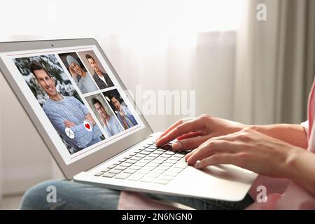 Donna che visita il sito di incontri via computer portatile al coperto, primo piano Foto Stock