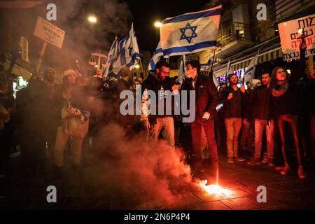 Gerusalemme, Israele. 09th Feb, 2023. I manifestanti illuminano una torcia nelle strade di Gerusalemme durante la manifestazione. Centinaia di persone hanno manifestato contro il nuovo governo di destra israeliano e contro la revisione giudiziaria a Gerusalemme. Credit: SOPA Images Limited/Alamy Live News Foto Stock