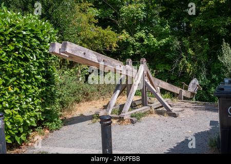 Una replica di uno sgabello medievale di legno, o sgabello di scolds situato sulle rive del fiume Avon a Christchurch nel Dorset Foto Stock