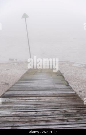Old slipway leading down to the Thames Estuary at Southend on Sea, Essex, UK, on a foggy day. Thick fog hanging over the River Thames Foto Stock