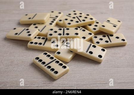 Pila di mattonelle di domino su tavolo di legno Foto Stock