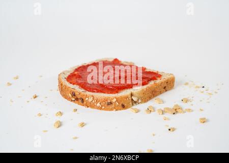 Vista dall'alto della salsa di pomodoro su una fetta di pane isolato su sfondo bianco con area di testo. Foto Stock