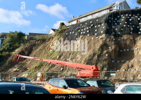 Lavori di stabilizzazione della scogliera presso il parcheggio di Quarry Lane a Falmouth, Cornovaglia, Inghilterra. I lavoratori in discesa svolgono un lavoro essenziale. Foto Stock