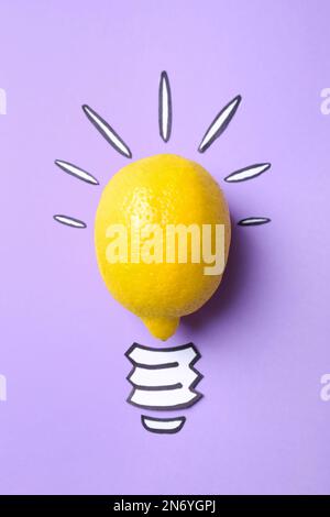 Composizione con limone come lampadina su sfondo viola, vista dall'alto. Concetto creativo Foto Stock