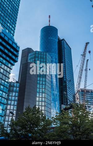 Moderni edifici finanziari, grattacieli con facciate in vetro a Francoforte sul meno. Sulla destra, gru da cantiere, dove si trovano edifici più alti Foto Stock