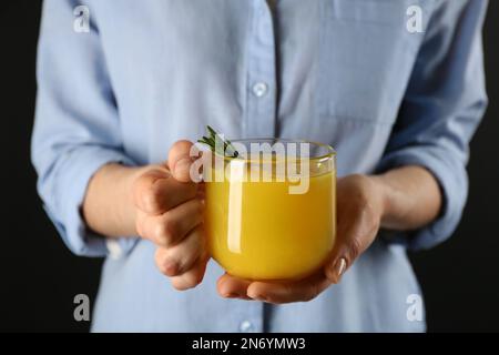 Donna che tiene la tazza dell'immunità che amplifica la bevanda nelle mani, primo piano Foto Stock