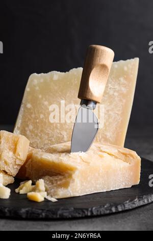 Donna che affetta pane di segale su un tagliere di legno. Un pezzo di  parmigiano, pomodori ciliegini, un piccolo camioncello di formaggio in  primo piano. Moody nat Foto stock - Alamy