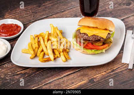 Cheeseburger con pomodori e Pickles con patatine fritte e ketchup Foto Stock