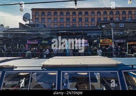 Londra, Inghilterra, Regno Unito - persone che girano intorno alle bancarelle del mercato e ai punti vendita di cibo di strada accanto al Regent's Canal al Camden Lock Market Foto Stock