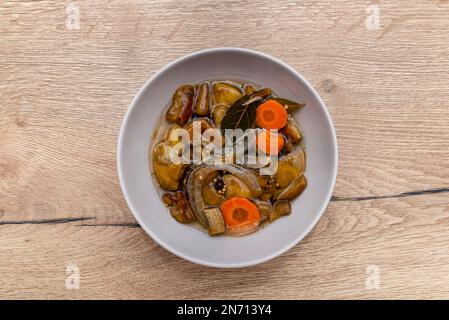 Funghi sottaceto in aceto in una piccola ciotola sul tavolo. Foto Stock