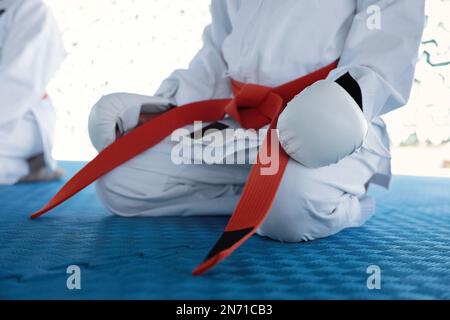 Bambini in kimono seduti sul campo di allenamento, primo piano Foto Stock