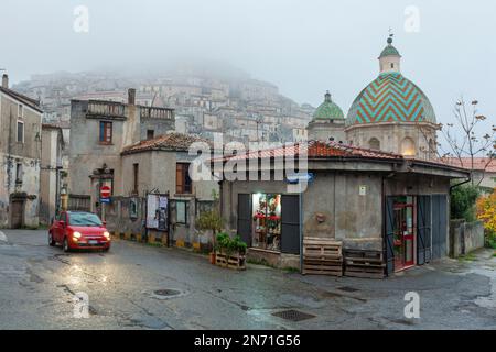 Strada a Morano Calabro con Collegiata della Maddalena nella nebbia autunnale Foto Stock