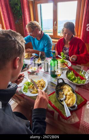 Vosges (Vogesen) Montagne, escursionista di famiglia a pranzo al ristorante in rifugio Ferme Auberge du Hahnenbrunnen in Alsazia (Elsass), Alto Reno (Oberelsass), Francia Foto Stock