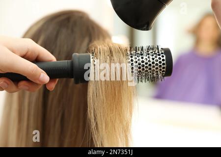 Stylist capelli del cliente che asciuga in salone di bellezza, primo piano Foto Stock