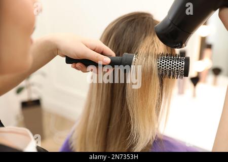 Stylist capelli del cliente che asciuga in salone di bellezza, primo piano Foto Stock