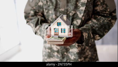 Programma SCRA. Esercito militare uomo in uniforme che tiene Nuova Casa Foto Stock