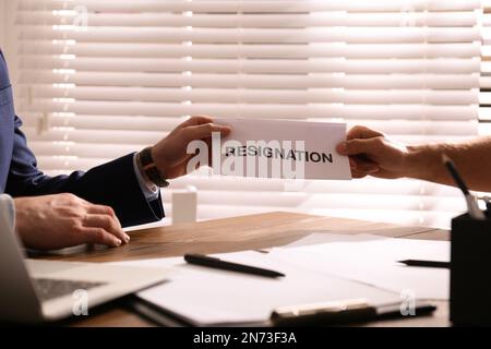 Dipendente che dà una lettera di dimissioni al capo in carica, primo piano Foto Stock