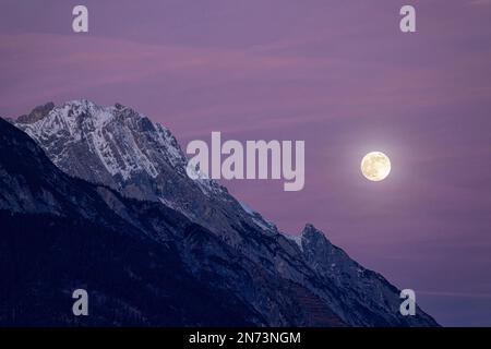 Luna piena sulle montagne invernali di Karwendel al crepuscolo serale Foto Stock