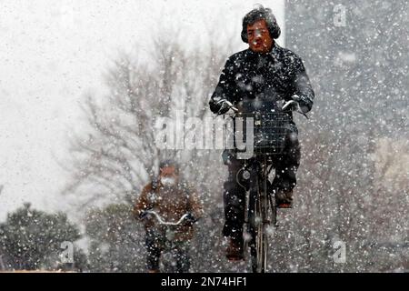 Tokyo, Giappone. 24th Jan, 2023. La gente viaggia in bicicletta nella neve che cade nel centro di Tokyo. (Foto di James Matsumoto/SOPA Images/Sipa USA) Credit: Sipa USA/Alamy Live News Foto Stock