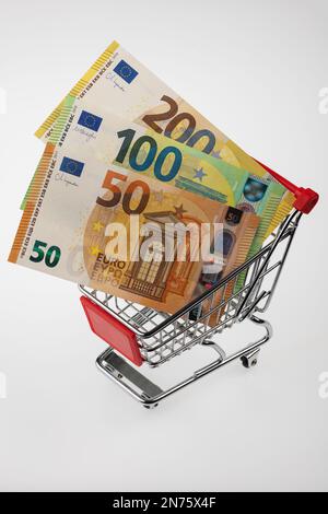 Carrello con banconote, diverso, immagine simbolo, shopping, sfondo bianco, Foto Stock