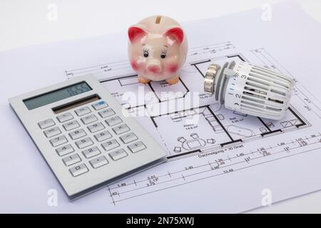 Piggy bank, calcolatrice, termostato radiatore, giacere sul disegno di costruzione, immagine simbolo, edificio, costi energetici, aumento dei costi di riscaldamento, sfondo bianco, Foto Stock