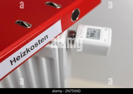 Cartella rossa con etichetta costi di riscaldamento, termostato radiatore WLAN FRITZ! DECT 302, il display visualizza 1ö°C., dettaglio, tecnologia Smart Home, immagine delle icone, networking, digitale, costi energetici, aumento dei costi di riscaldamento, sfondo bianco, Foto Stock