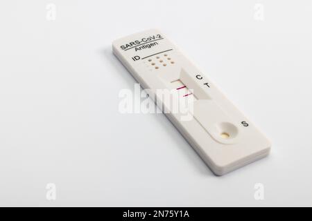 Cassetta per test antigeni Rapid SARS-COV-2 con risultati positivi, fondo bianco, Foto Stock