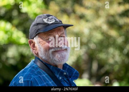 Seattle, Washington, Stati Uniti. Ritratto di un uomo di 75 anni all'esterno che indossa un cappellino da baseball. Foto Stock