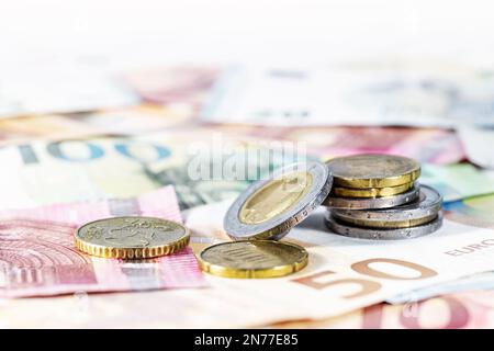 Denaro. Alcune monete in euro su banconote sfocate. Concetto di economia per la valuta, il commercio, la finanza domestica e l'inflazione, spazio della copia, fuoco selezionato, molto narro Foto Stock
