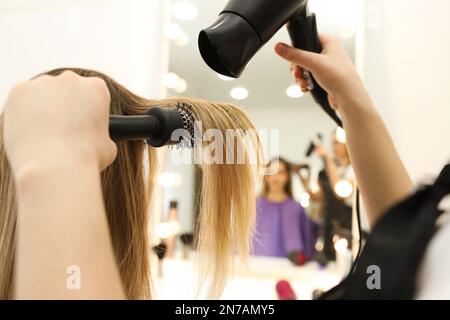 Stylist capelli del cliente che asciuga in salone di bellezza, primo piano Foto Stock