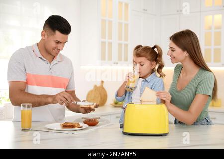 Buona colazione con pane tostato al tavolo in cucina Foto Stock