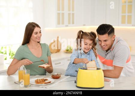 Buona colazione con pane tostato al tavolo in cucina Foto Stock